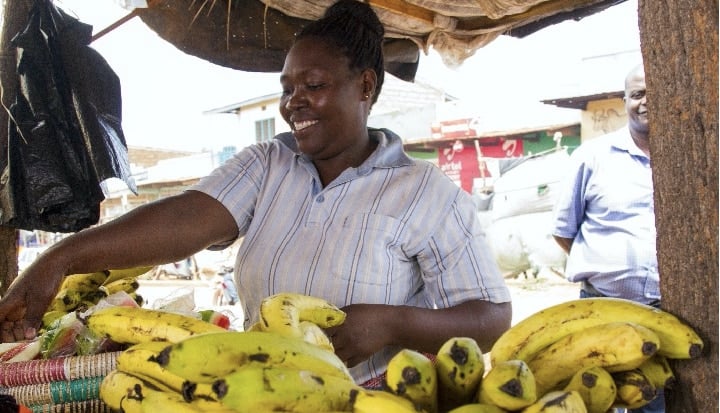 Woman smiling, Selling Banana's on a stall