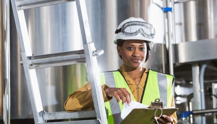 black-woman-working-in-factory-with-clipboard-hardhat