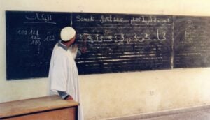 Teacher at a black board. Waste and Education