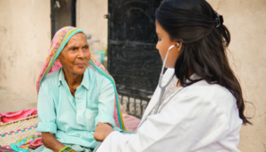 Female doctor examining rural indian senior woman at home. stock photo