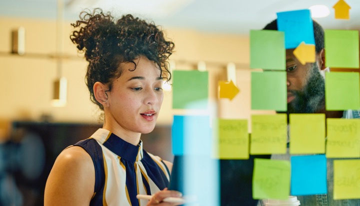 Two business professionals discussing ideas in an office- Portfolio Approach to Impact